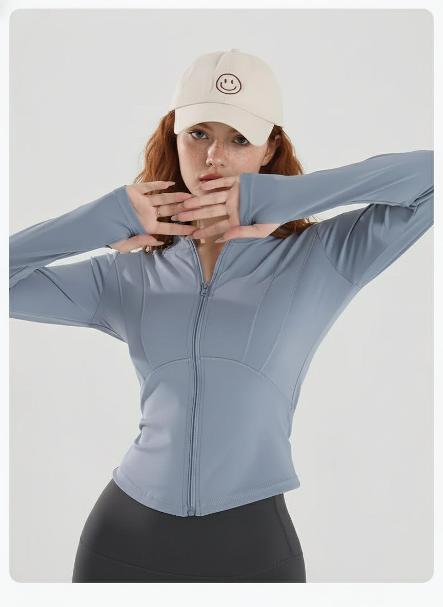 Person wearing a light blue long-sleeve top and black pants with a beige cap on a light gray background