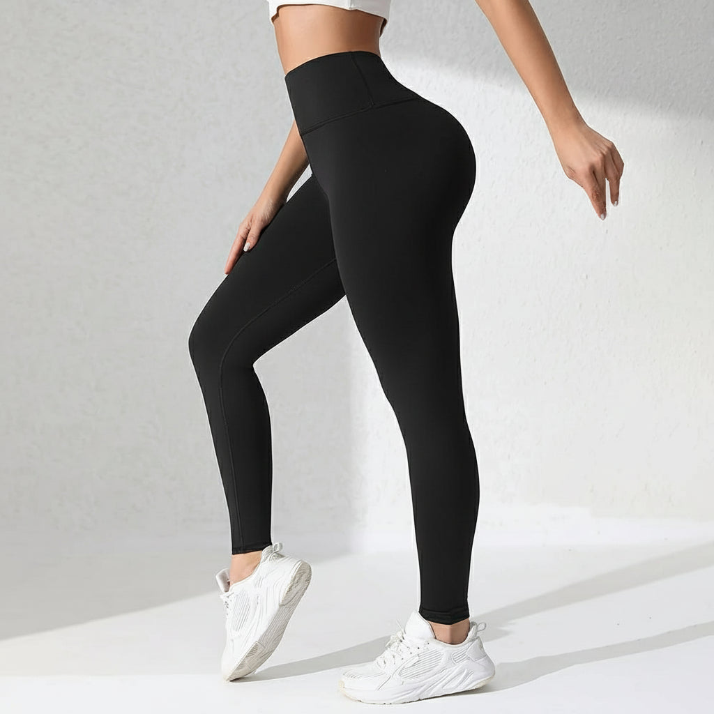 Person wearing black leggings with a flame graphic on a gray background